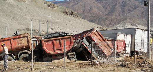 Heavy trailers pushed together and buried in mud in Chañaral