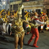 Carnival in Montevideo: Vedette in front of drummers with amazing masks