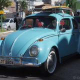 A beautiful classic VW Beetle with surf boards on the roof rack. This one has the so-called 'Export bumper bars', which were designed for the US market with an extra curved tube on the top.