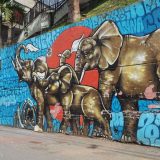 Elephants waving white pieces of cloth. The elephants symbolise the African roots of the Comuna 13; the white flags, peace.