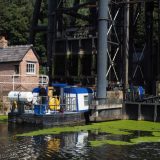 The Anderton Boat Lift, as seen from below, with a wide beam tourist boat entering one of the caissons to go up.