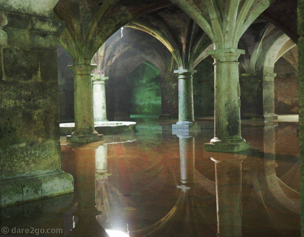 Inside the Citerne Portugaise, found in the Portuguese City of Mazagan, showing carved columns reflected in the water.