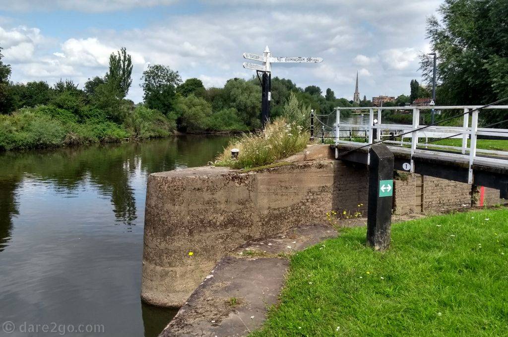 A canal direction sign (like a road sign) at the junction of the River Severn and the Worcester & Birmingham Canal. It reads: Birmingham 30 miles 58 Locks.