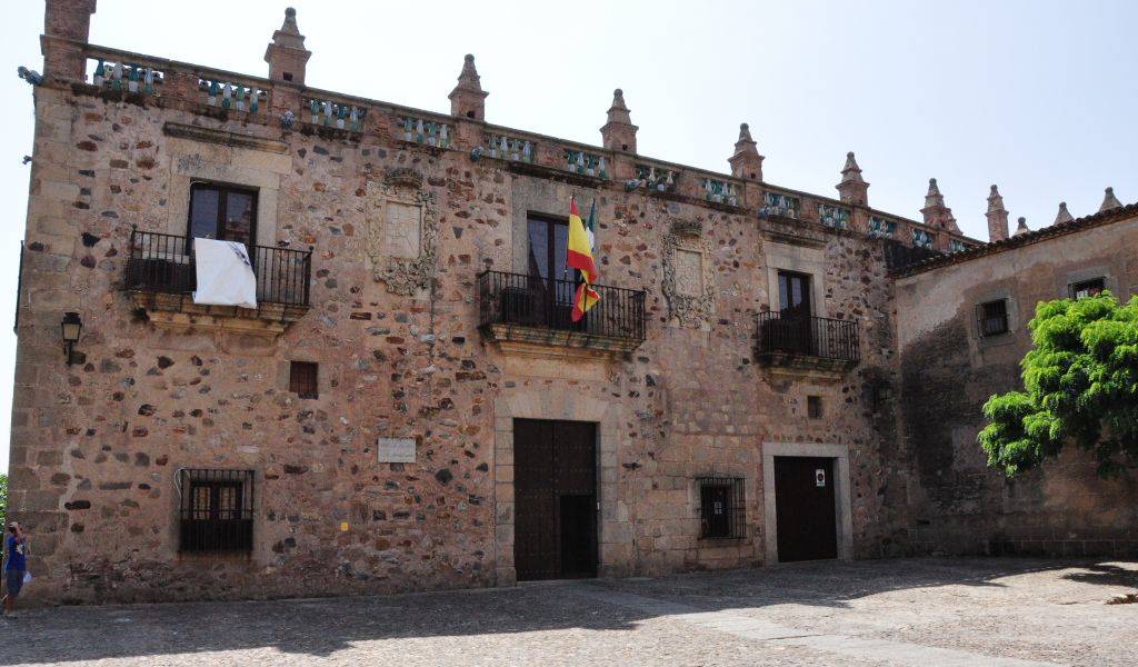 The facade of Casa de las Veletas is very different to most other palaces in Cáceres. It was never fortified, hence has more openings to the outside world and a much more decorated facade. Note the colourfully glazed ceramic balusters topping the exterior wall!
