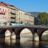 The Latin Bridge in Sarajevo - the city's oldest bridge. In the background on the right of the photo, the rebuilt townhall of Sarajevo, and on top of the hill above, the White Fortress. This corner made history: it was here that Archduke Franz Ferdinand of Austria was assassinated, which sparked WWI.