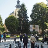 A group of men playing chess for leisure on a square in front of Sarajevo's cathedral.