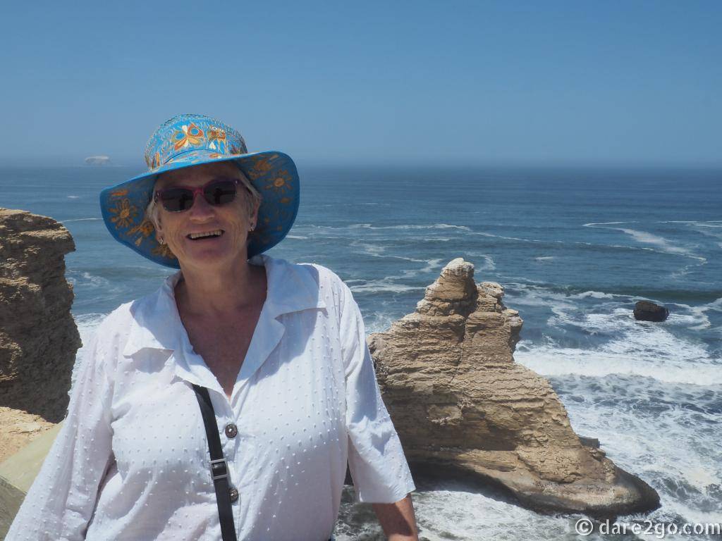 The Paracas Reserve in Peru. Yasha is happy about the beautiful weather and the view of the "cathedral" behind her.