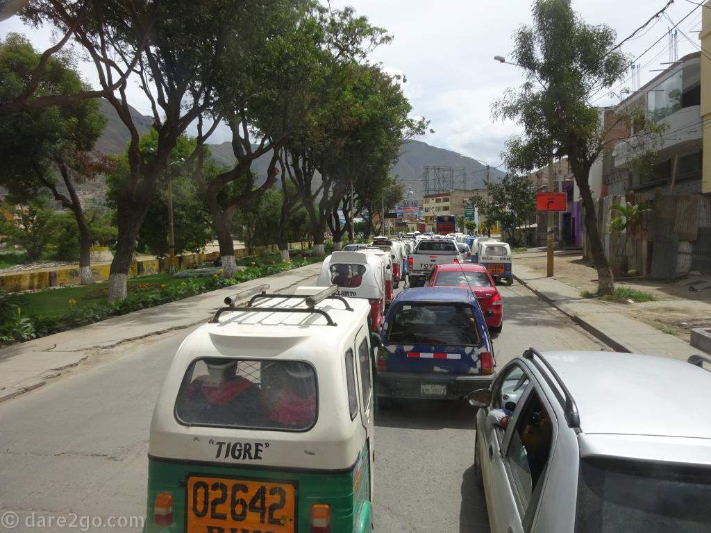 Local drivers squeezing along the main road into a town - not even leaving a full lane for oncoming traffic. Tuk-tuks are the main public transport almost everywhere in rural Peru.