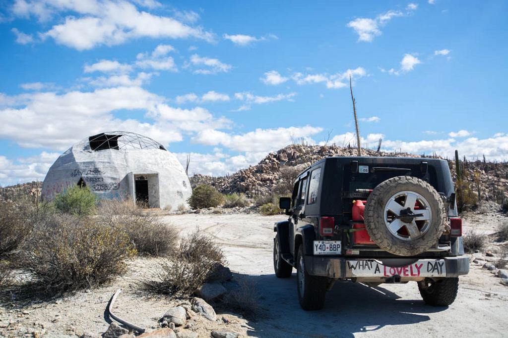 The "End of the World" trip has ended (a jeep parked in front of a desolate dome house)