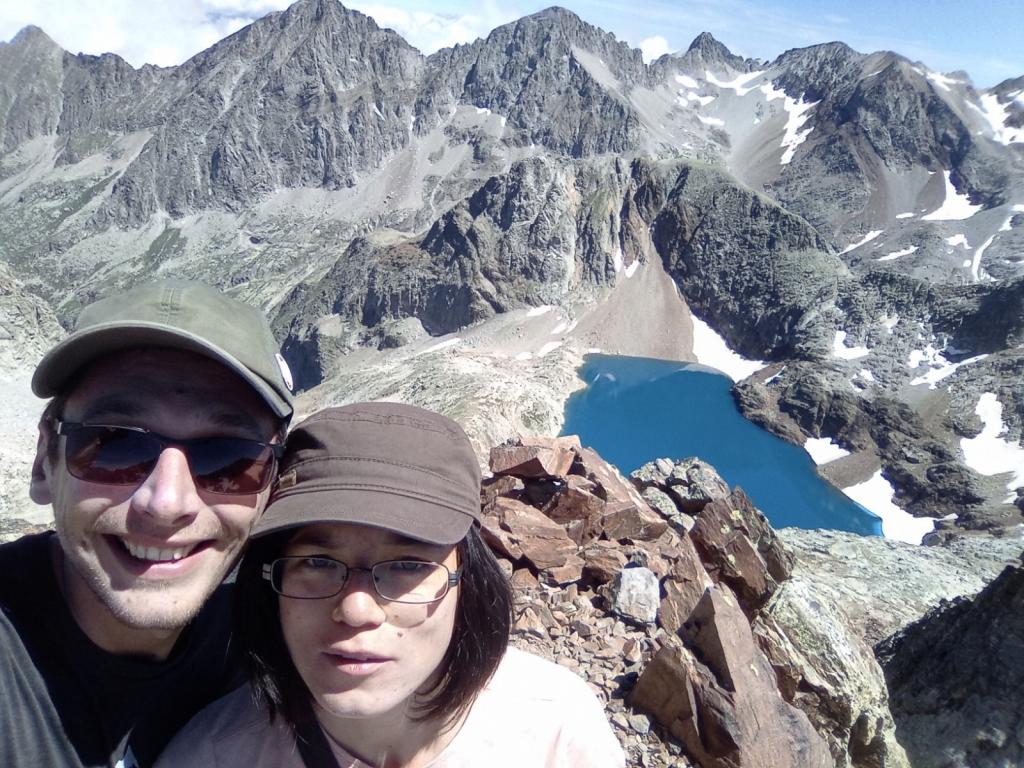 Instead of exotic foreign destinations we explore the beautiful Pyrenees in our home of France (couple with a glacier lake in the background)