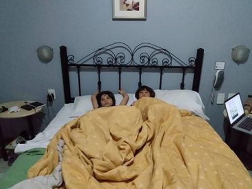 Our temporary crowded hotel quarantine (2 kids laying in a bed)